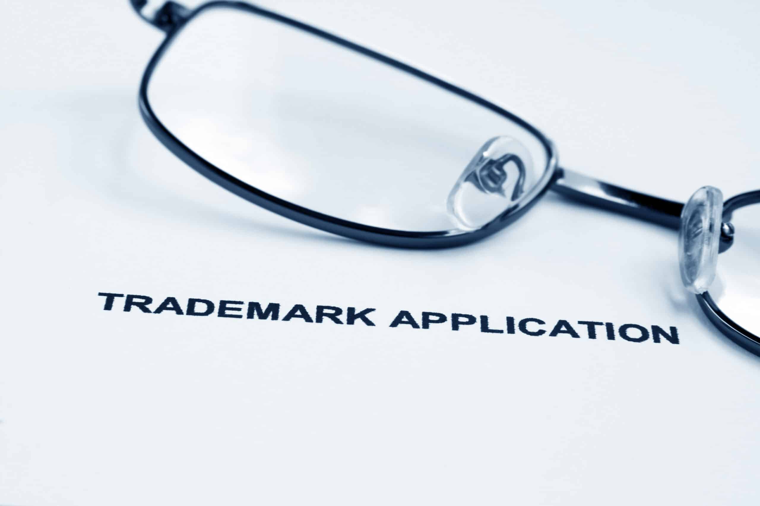 A pair of glasses rests on a trademark application